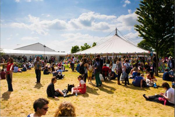 Ysgol Merllyn at Hay Festival People sat on the grass enjoying the sunshine at Hay Literature Festival